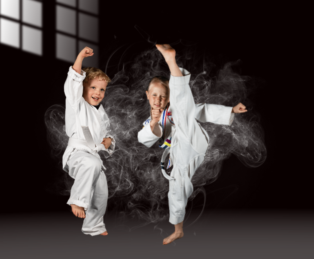 Two young boys are practicing karate in a dark room.