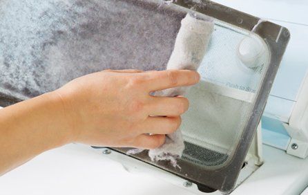 Woman taking the lint out from dirty air filter Woman taking the lint out from dirty air filter