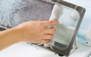 Woman taking the lint out from dirty air filter