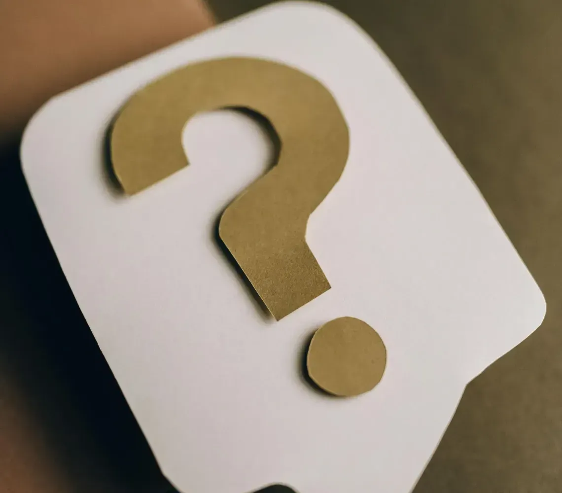 White speech bubble with a gold question mark on a dark background.