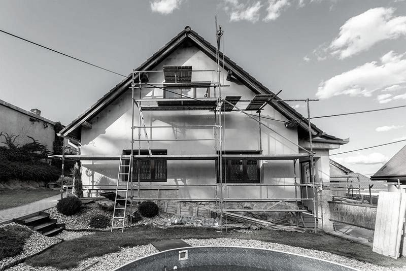 Extérieur de la maison en cours de rénovation avec échafaudage.