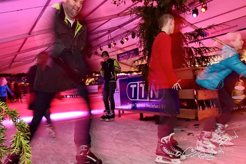 Een groep mensen is aan het schaatsen op een ijsbaan.
