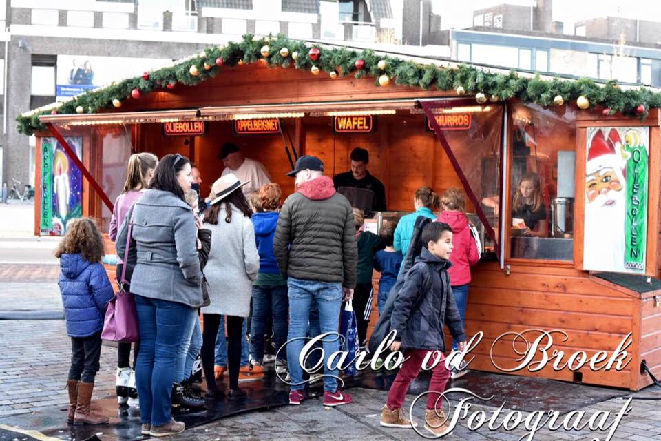 Een groep mensen staat in de rij op een kerstmarkt.