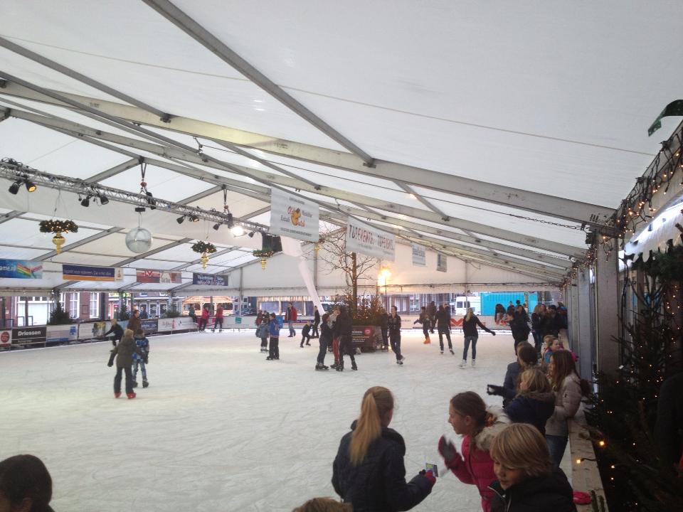 Een groep mensen schaatst op een overdekte ijsbaan