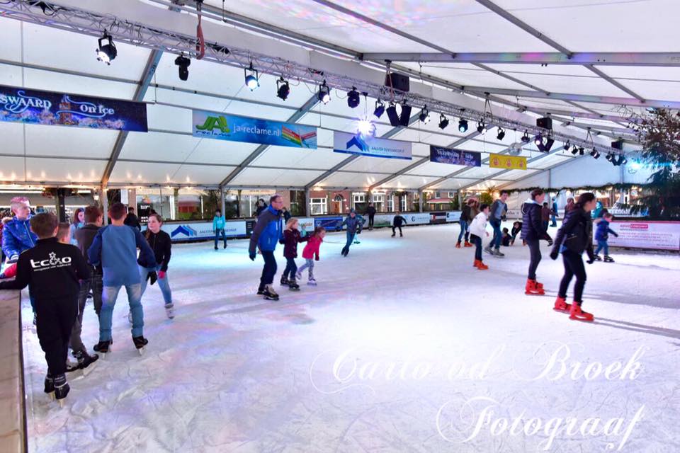 Een groep mensen schaatst op een overdekte ijsbaan