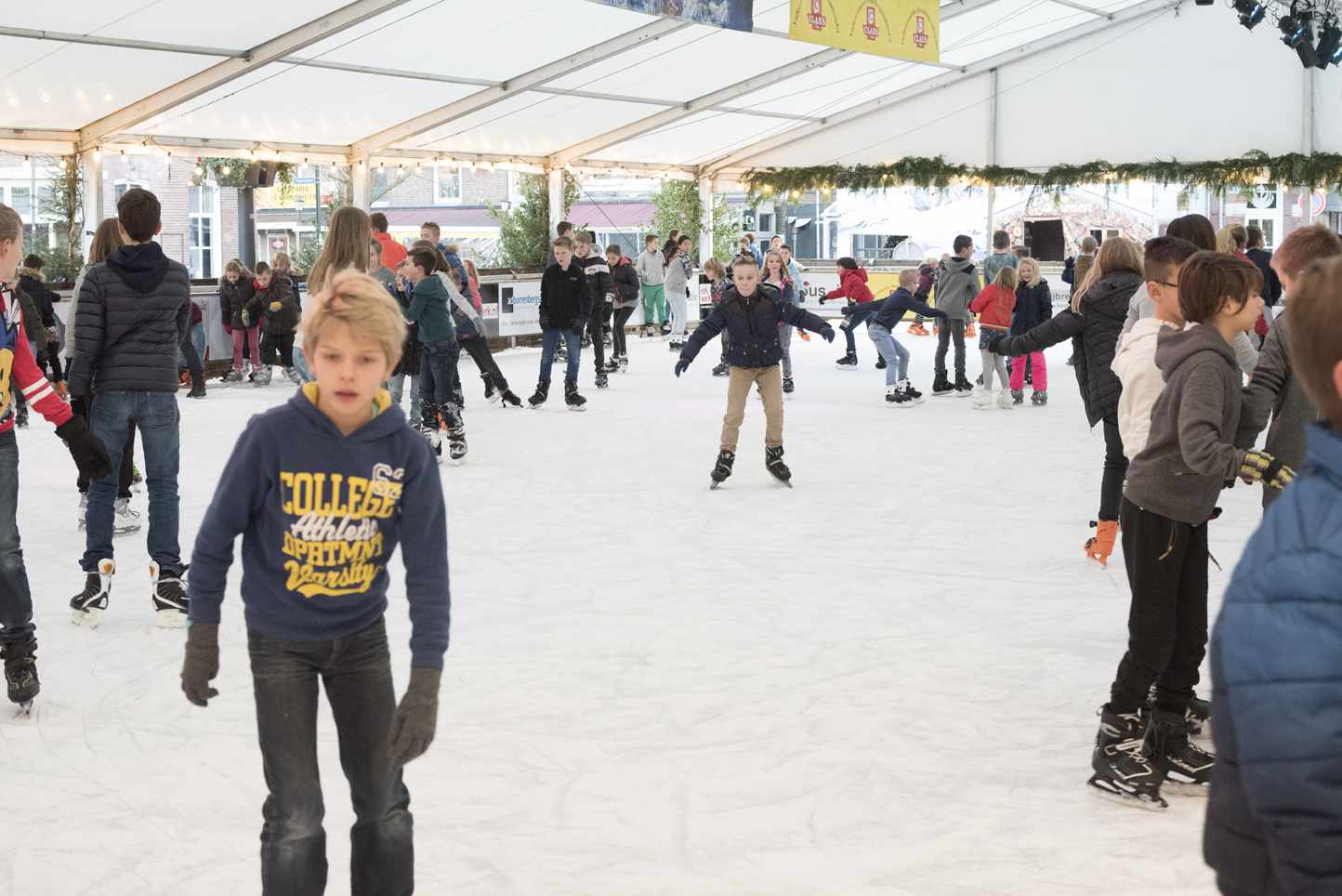 Een groep mensen is aan het schaatsen op een ijsbaan.