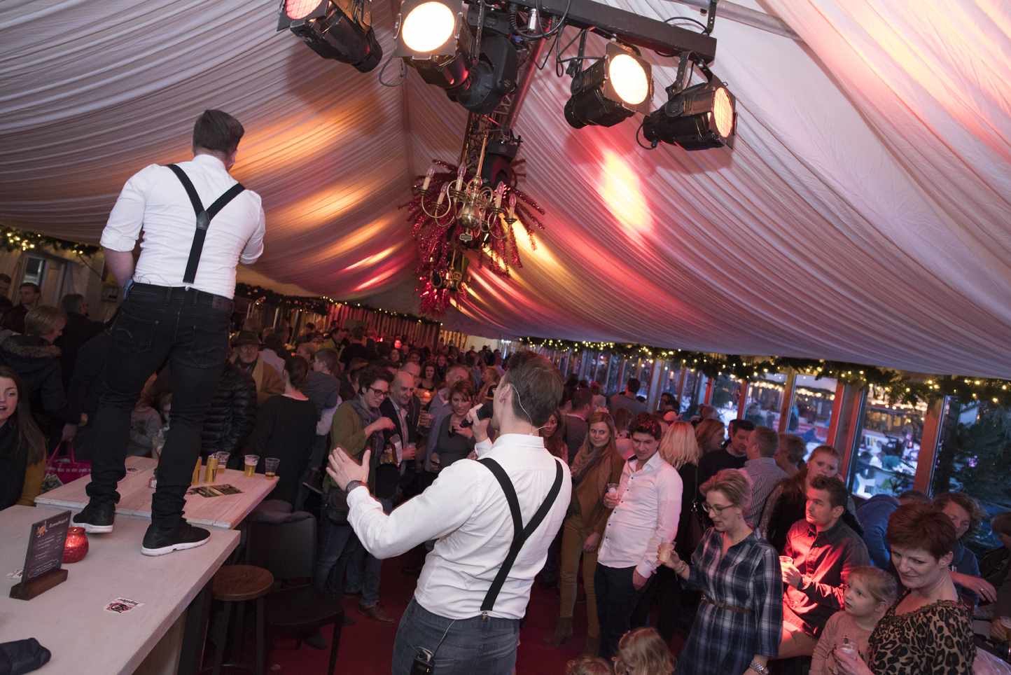 Een groep mensen danst in een tent.