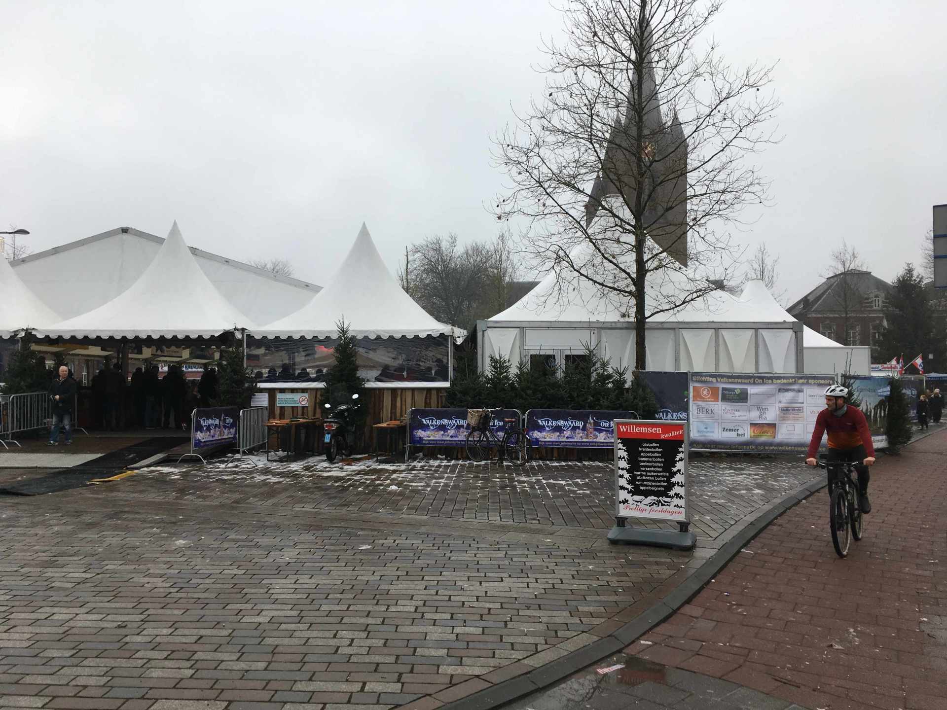 Een man fietst over een geplaveide straat.