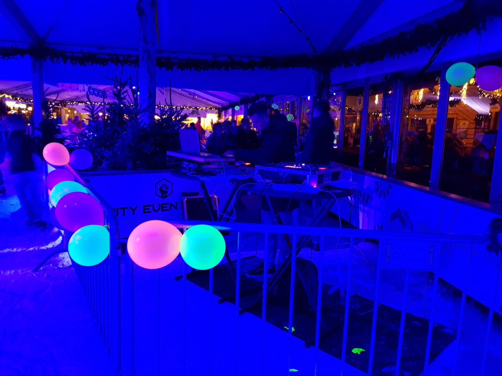 Een groep mensen staat in een kamer met lichtgevende ballonnen.