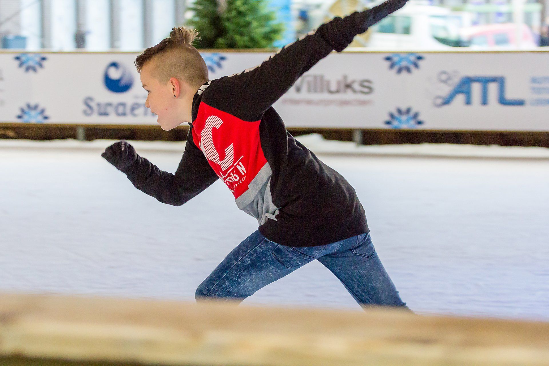 Een jonge jongen schaatst op een ijsbaan.