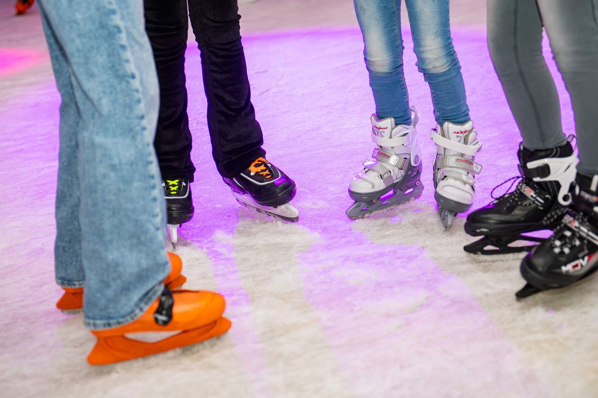 Mensen met schaatsen op een ijsbaan.