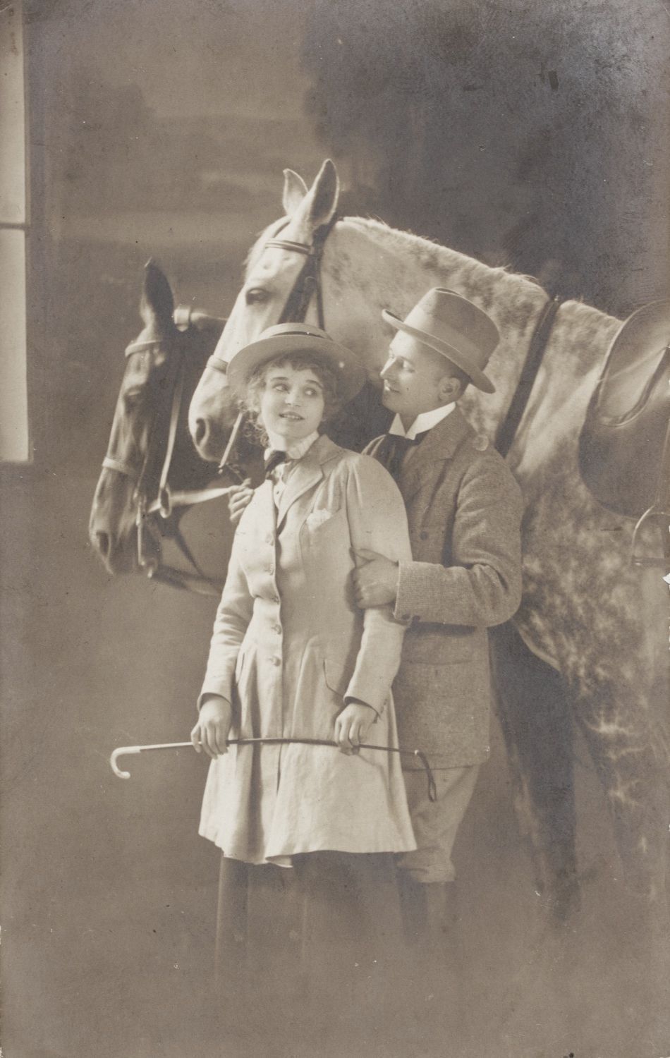 A man and a woman standing next to two horses