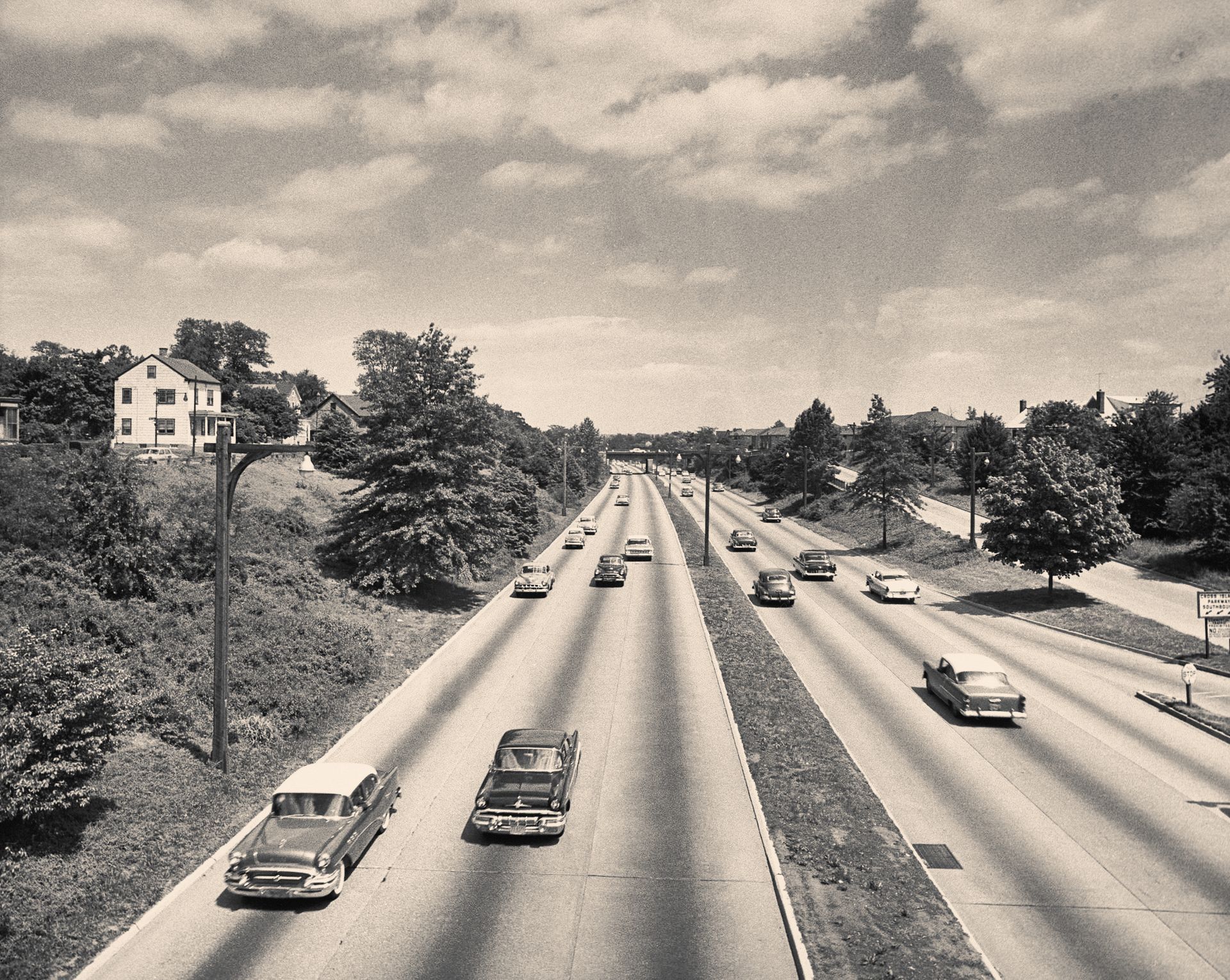 A black and white photo of cars driving down a highway