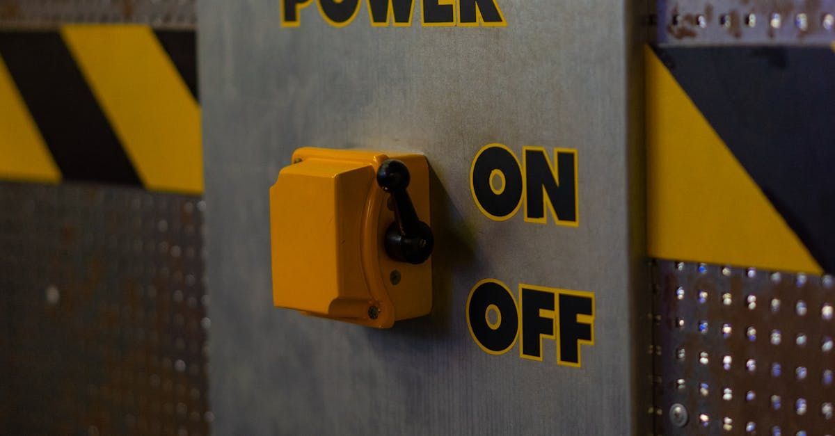 A yellow switch on a metal wall that says on and off.