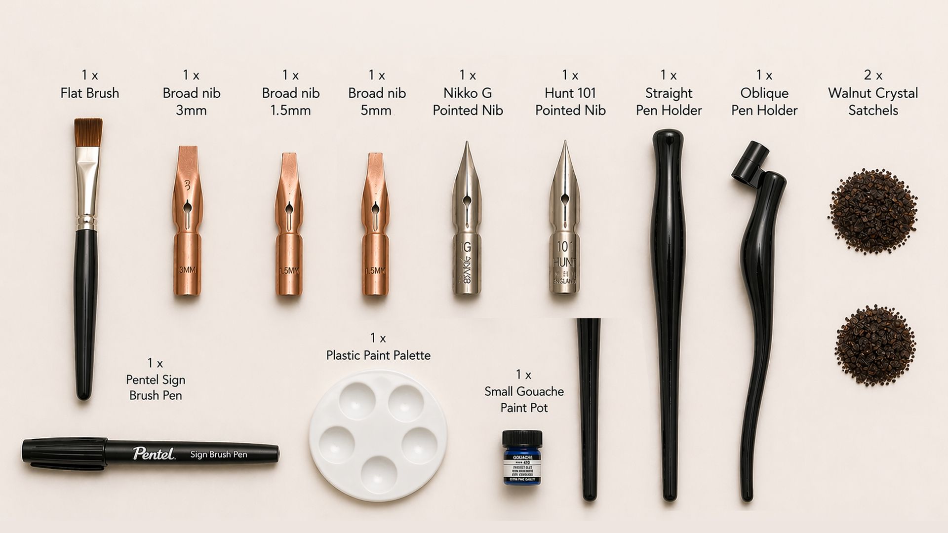 Calligraphy kit laid out with pens, nibs, ink, palette, and paper examples on a white background