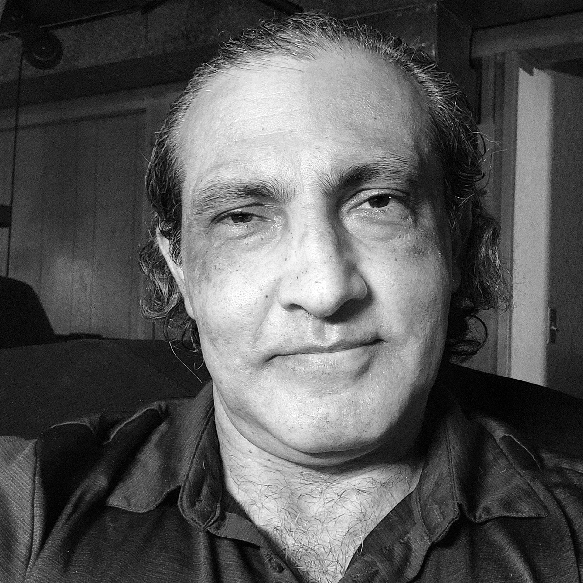Black-and-white close-up portrait of a Ramin Moheb, facing the camera with a neutral expression.