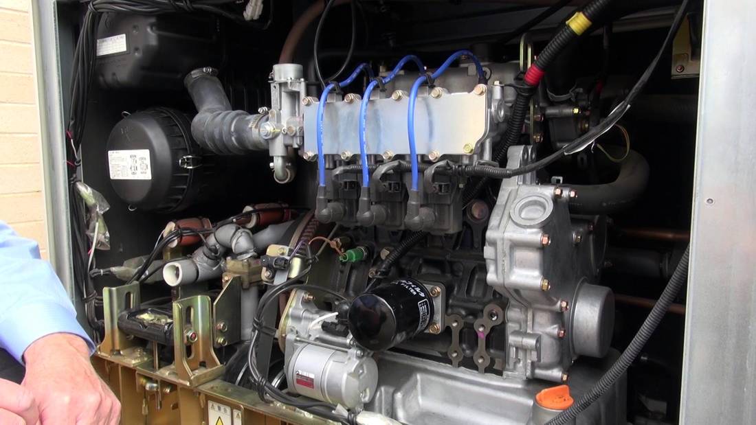 A man is looking at the inside of a diesel engine.