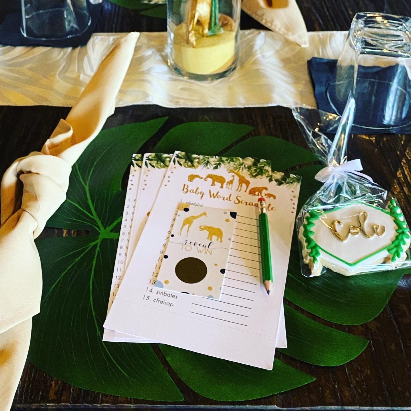 A baby shower game is sitting on a table next to a cookie