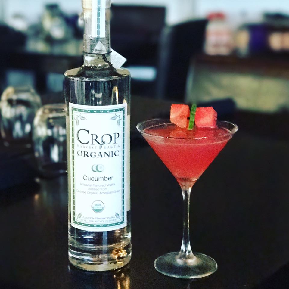 A bottle of crop organic cucumber vodka next to a martini