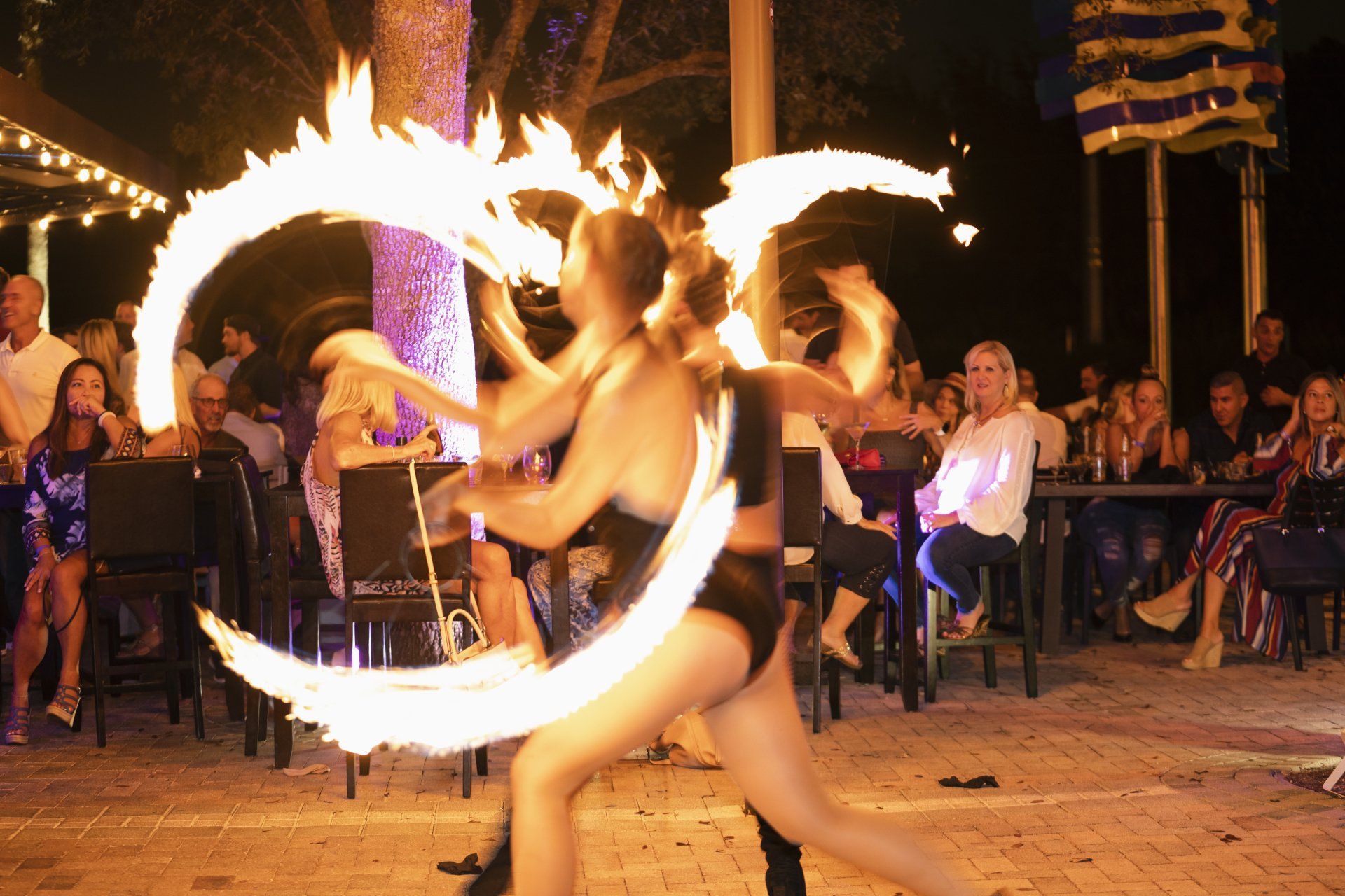 A group of women are performing a fire show in front of a crowd.