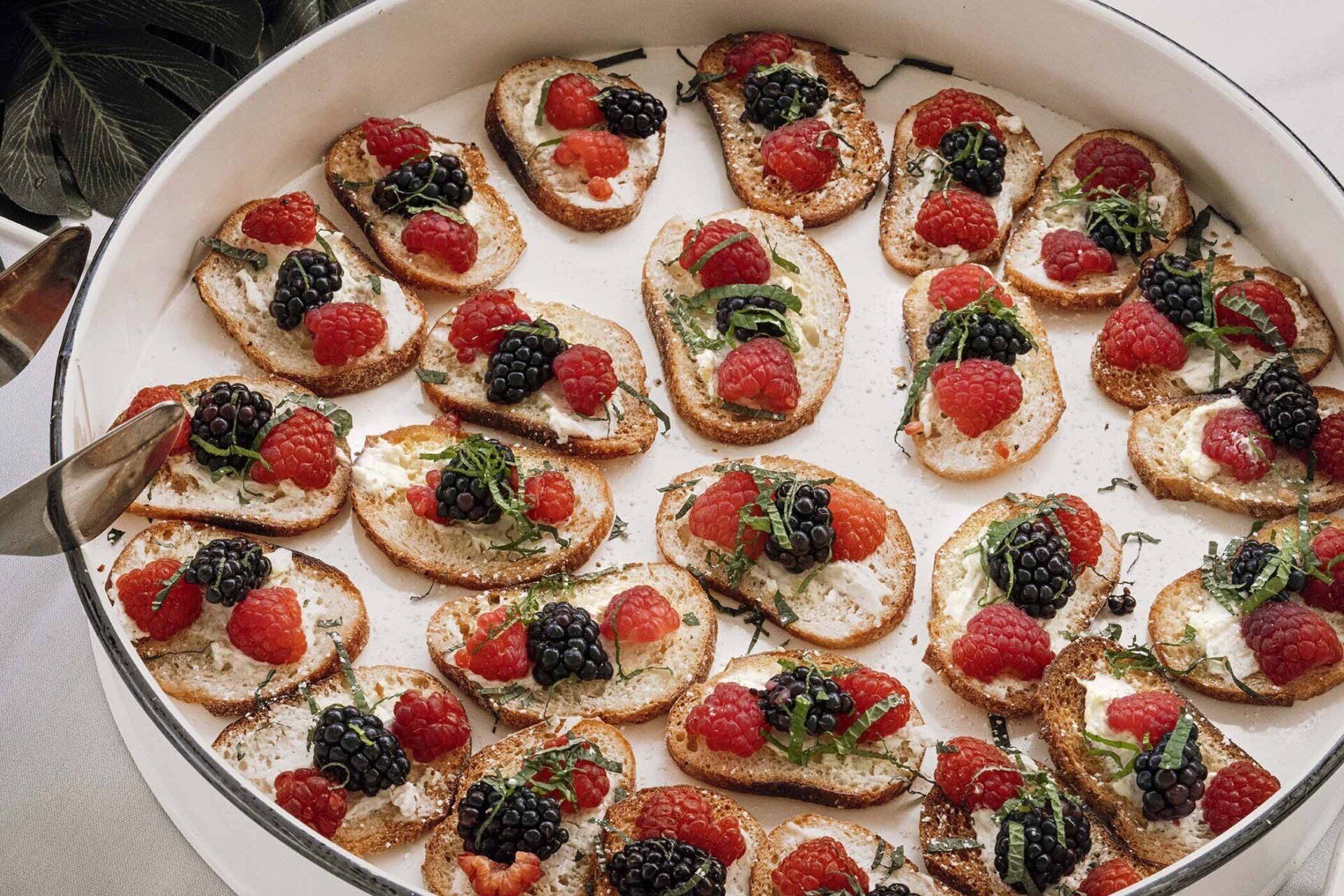 A tray of food with raspberries and blackberries on it
