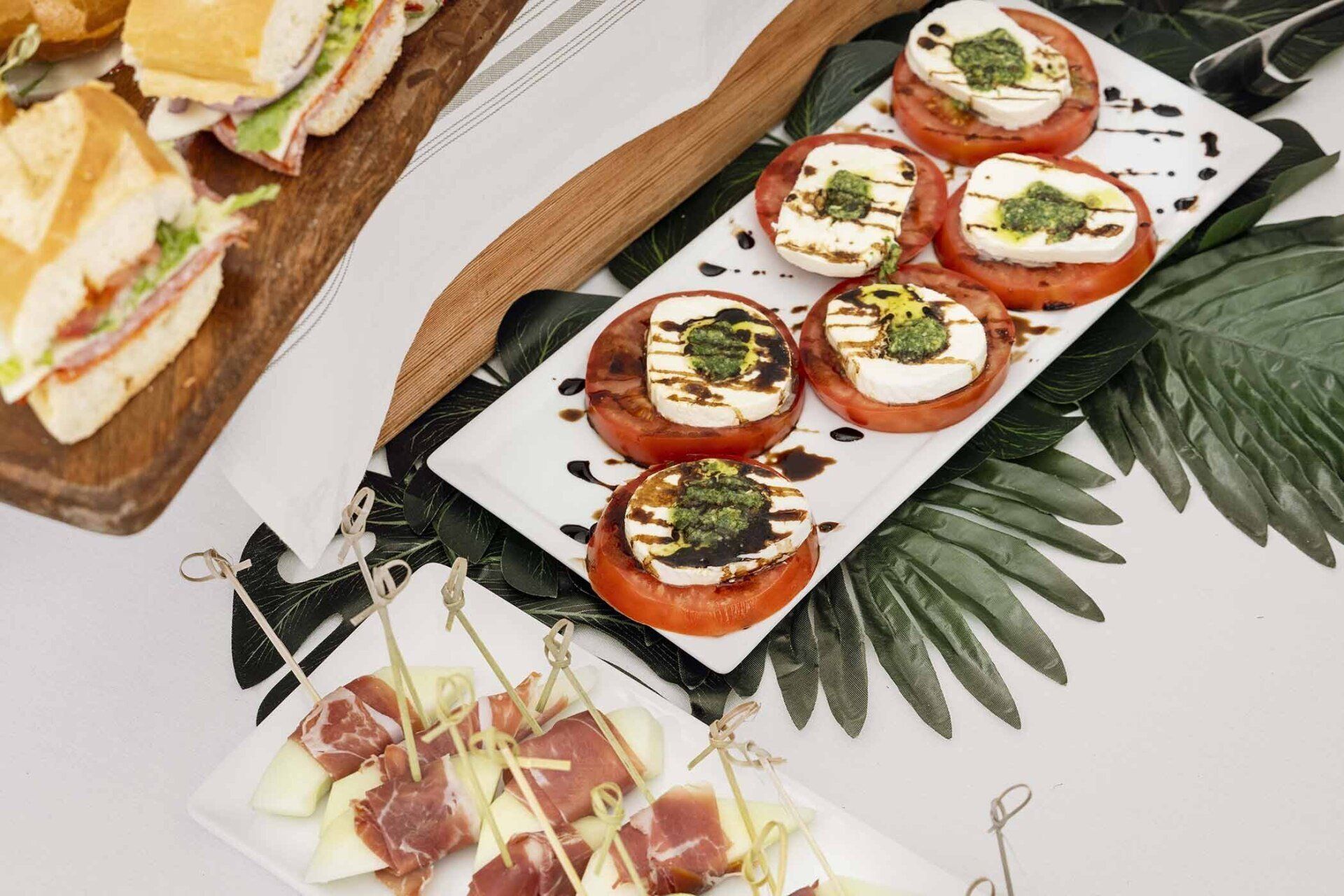A table topped with plates of food including sandwiches and appetizers.