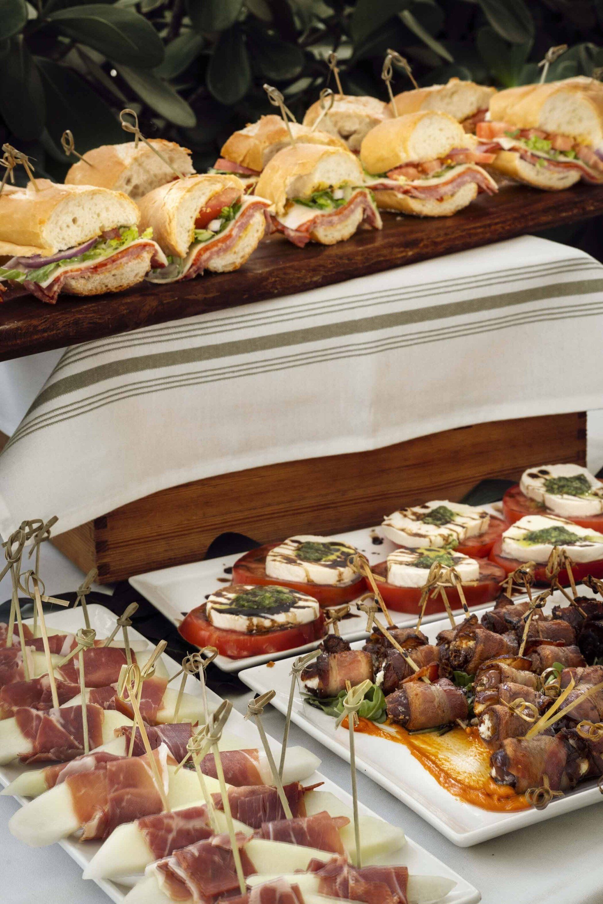 A table topped with plates of food and sandwiches.