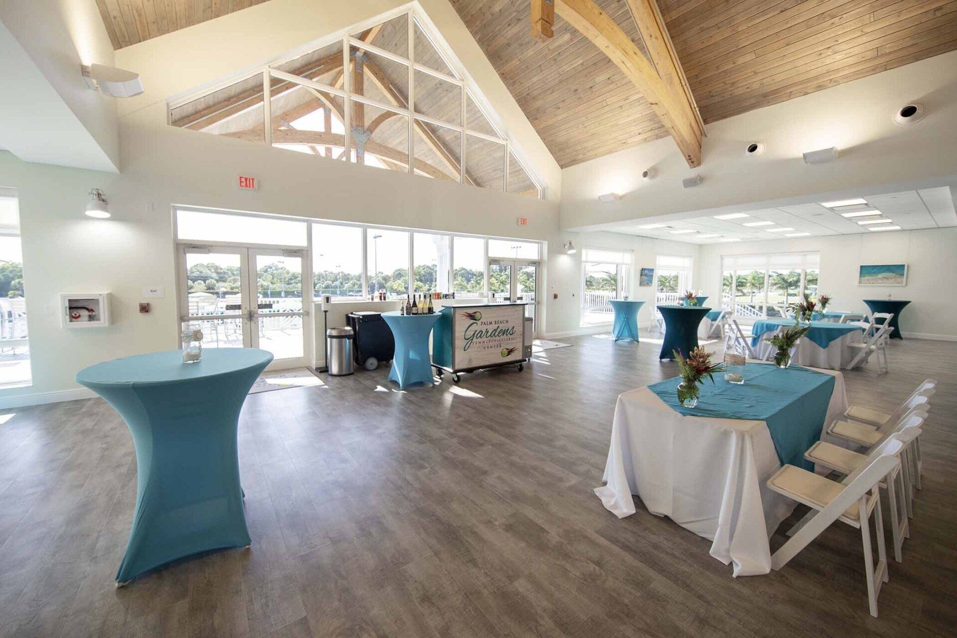 A large room with tables and chairs set up for a wedding reception.