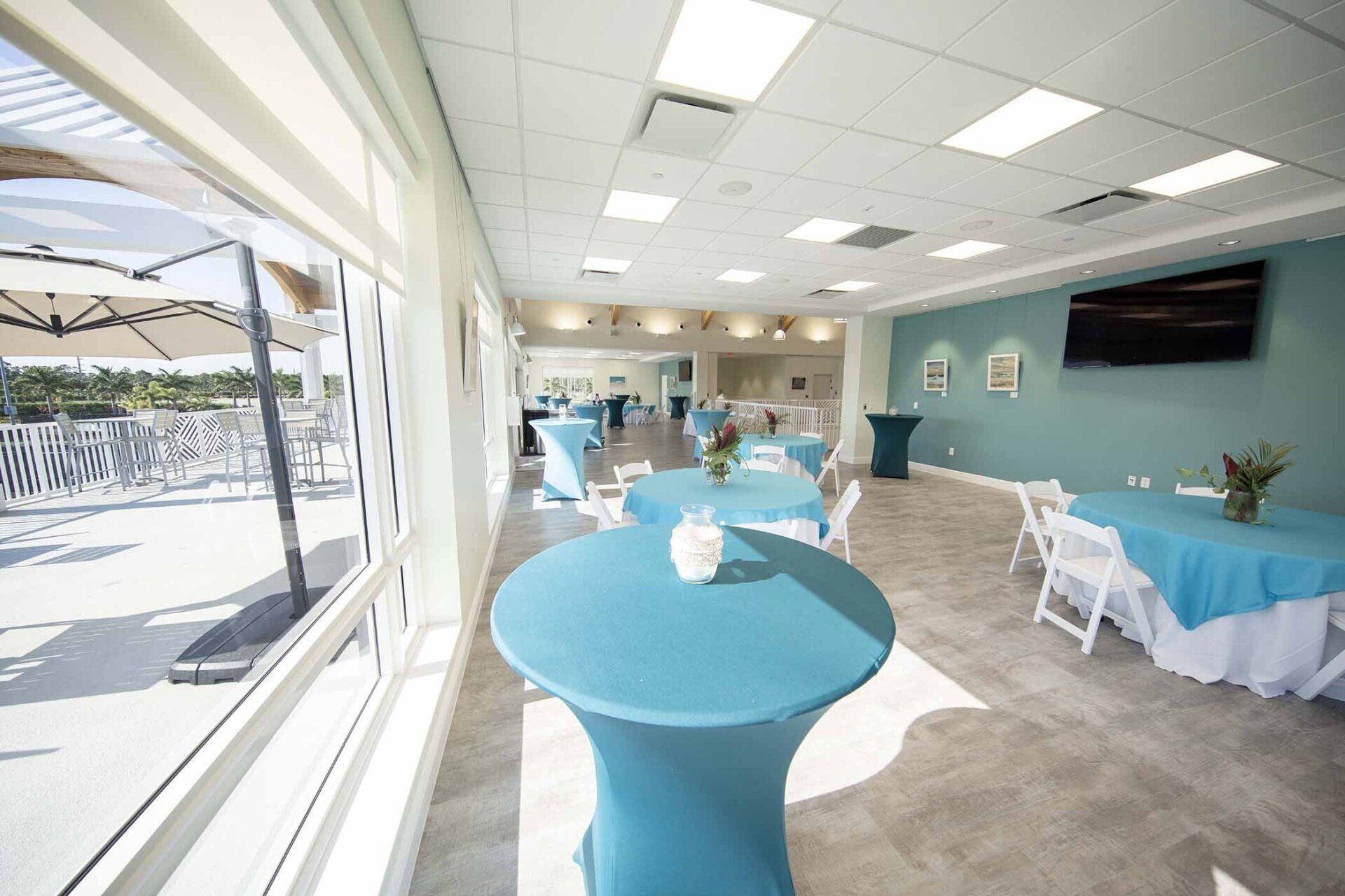 A large room with blue tables and white chairs