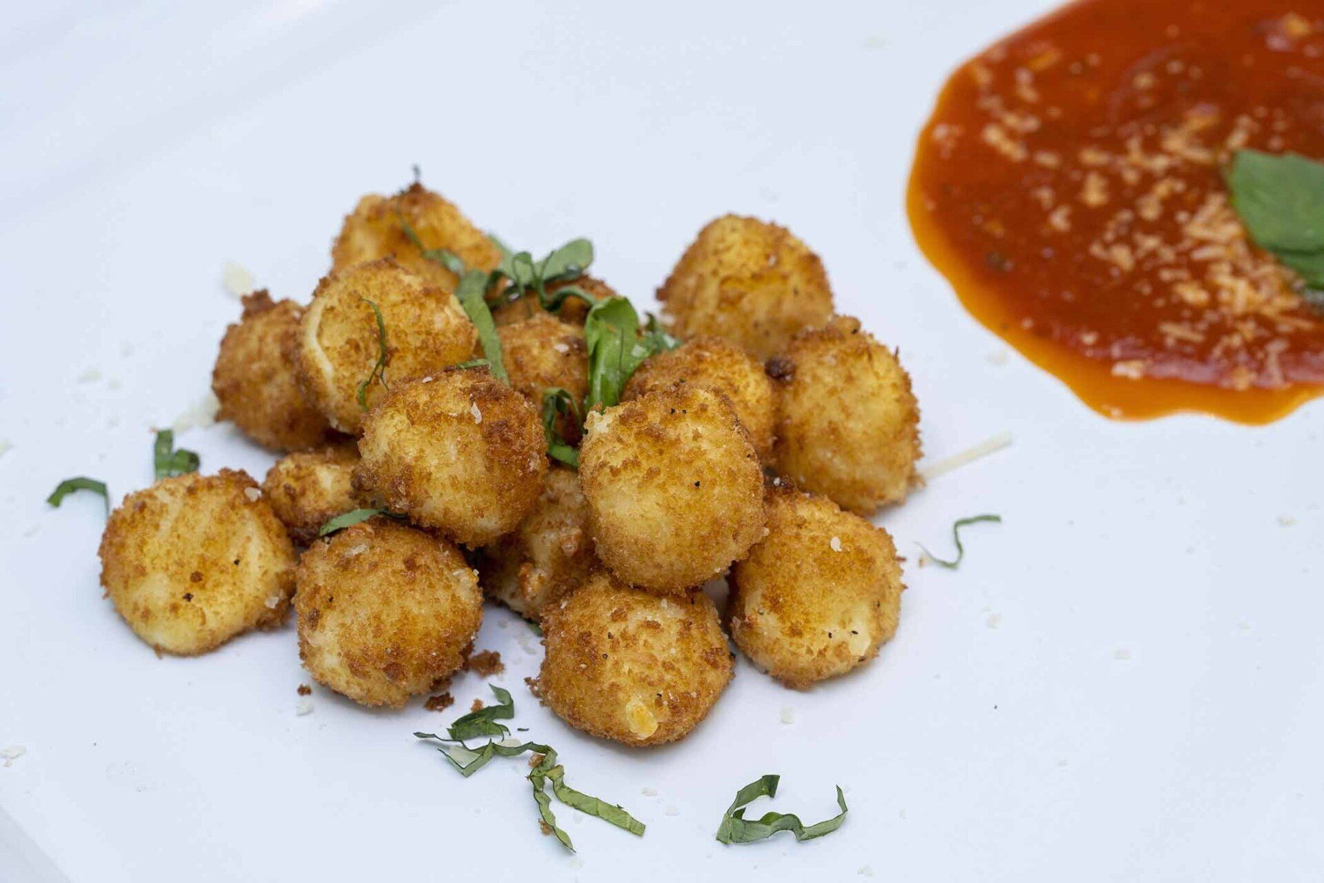 A white plate topped with fried potatoes and tomato sauce.
