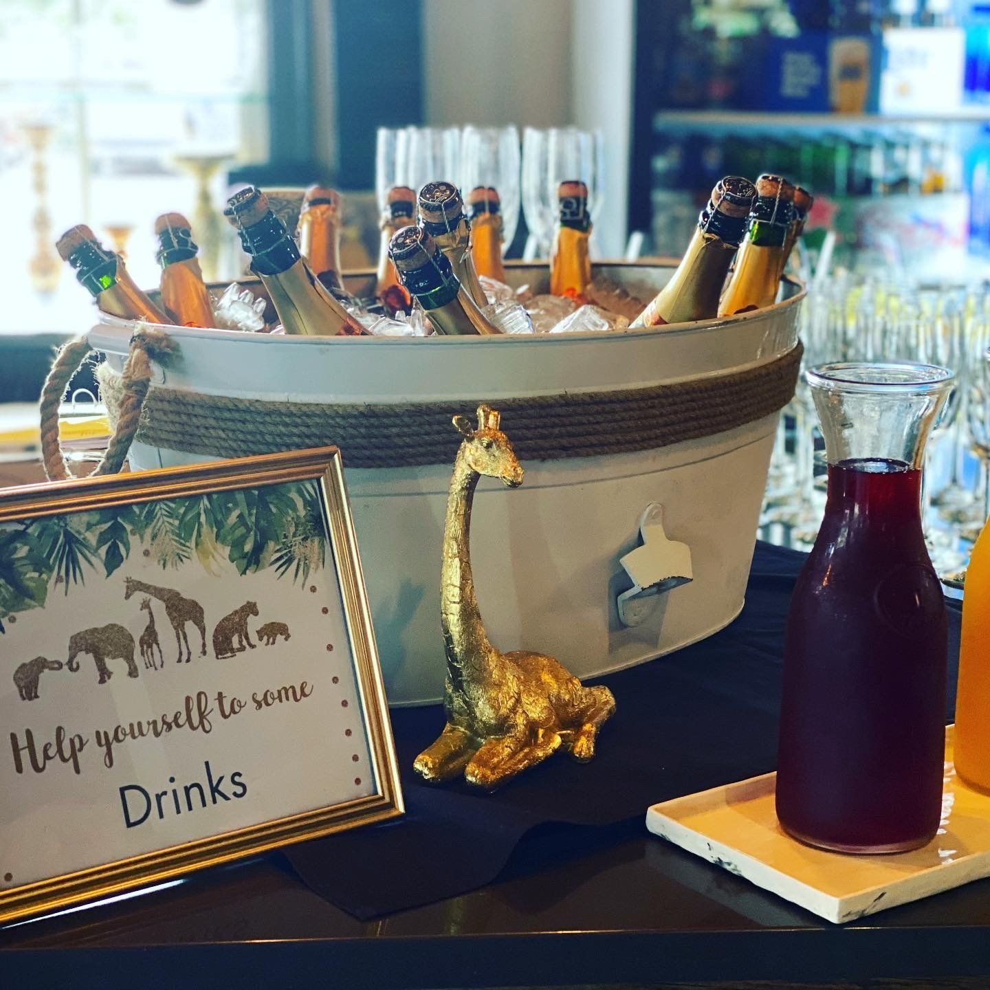 A table with a sign that says help yourself to some drinks