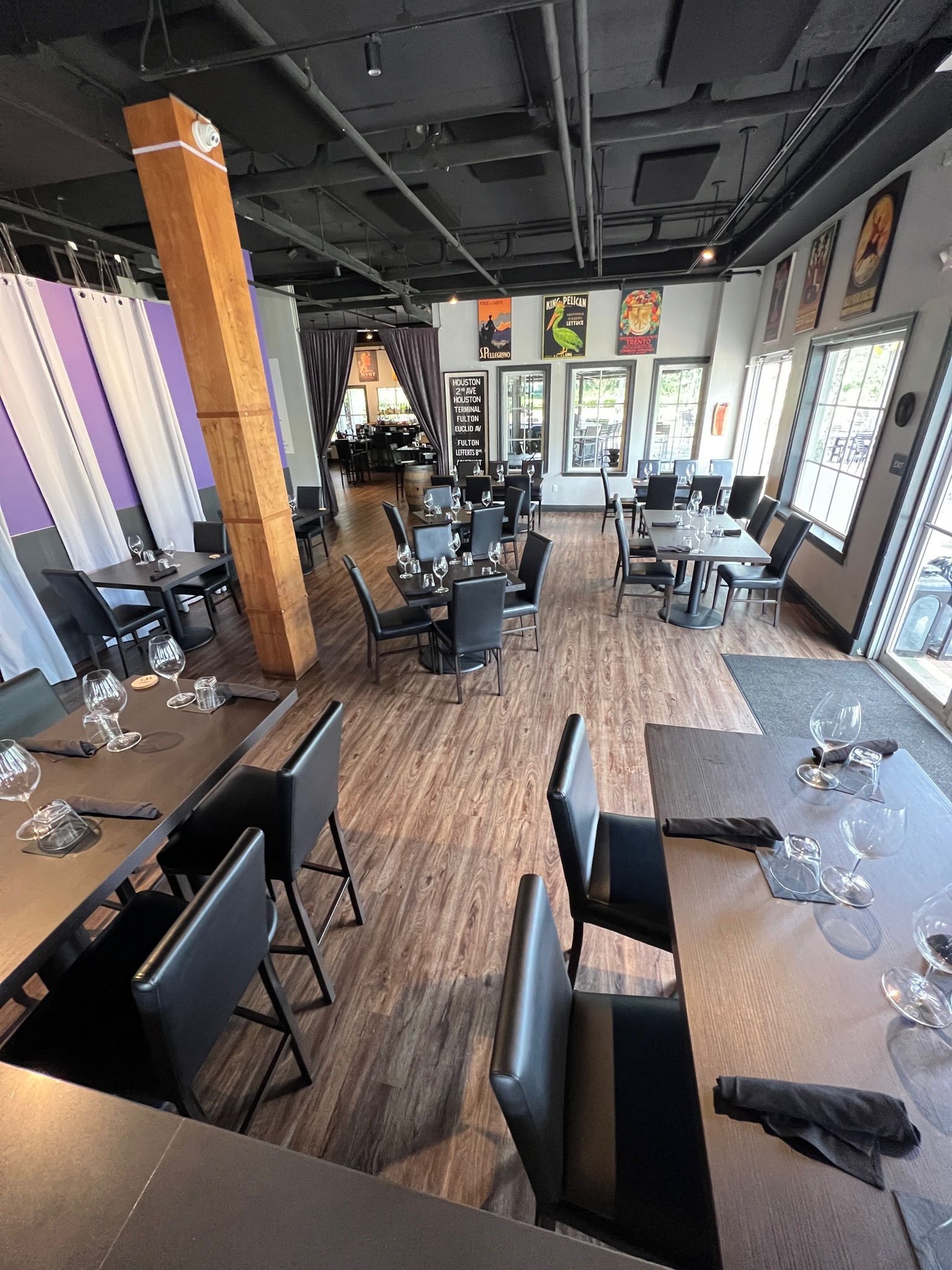 A large empty room with wooden floors and tables.