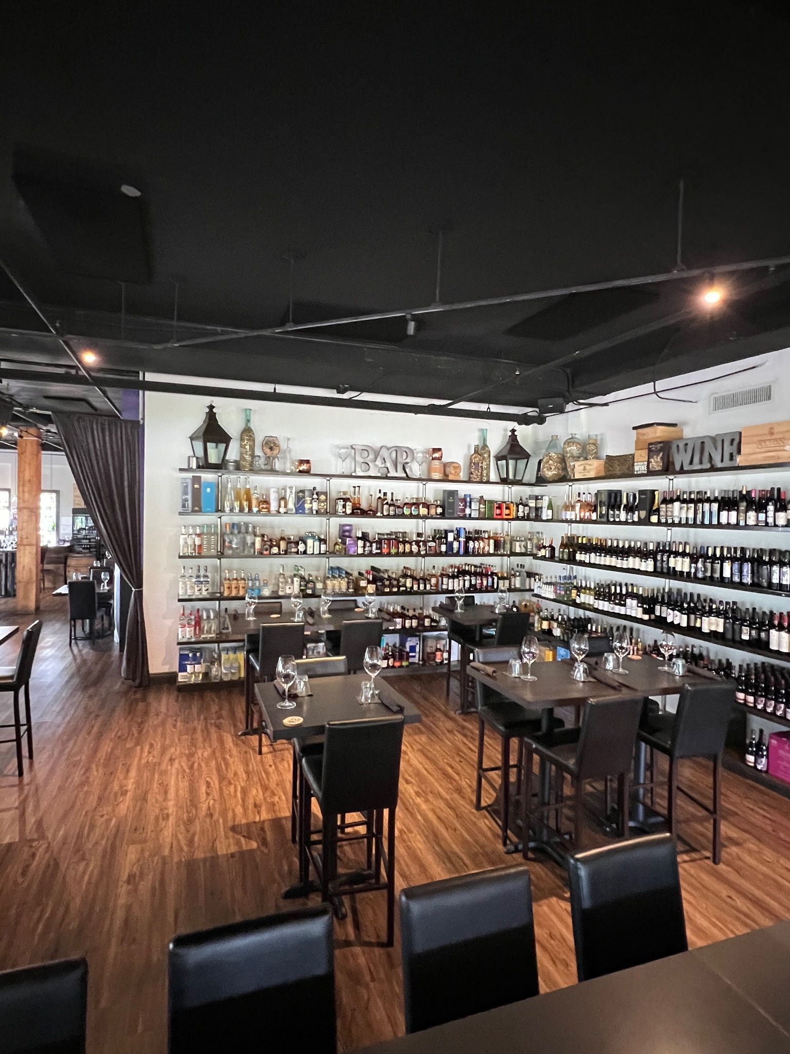 A large empty room with wooden floors and tables.