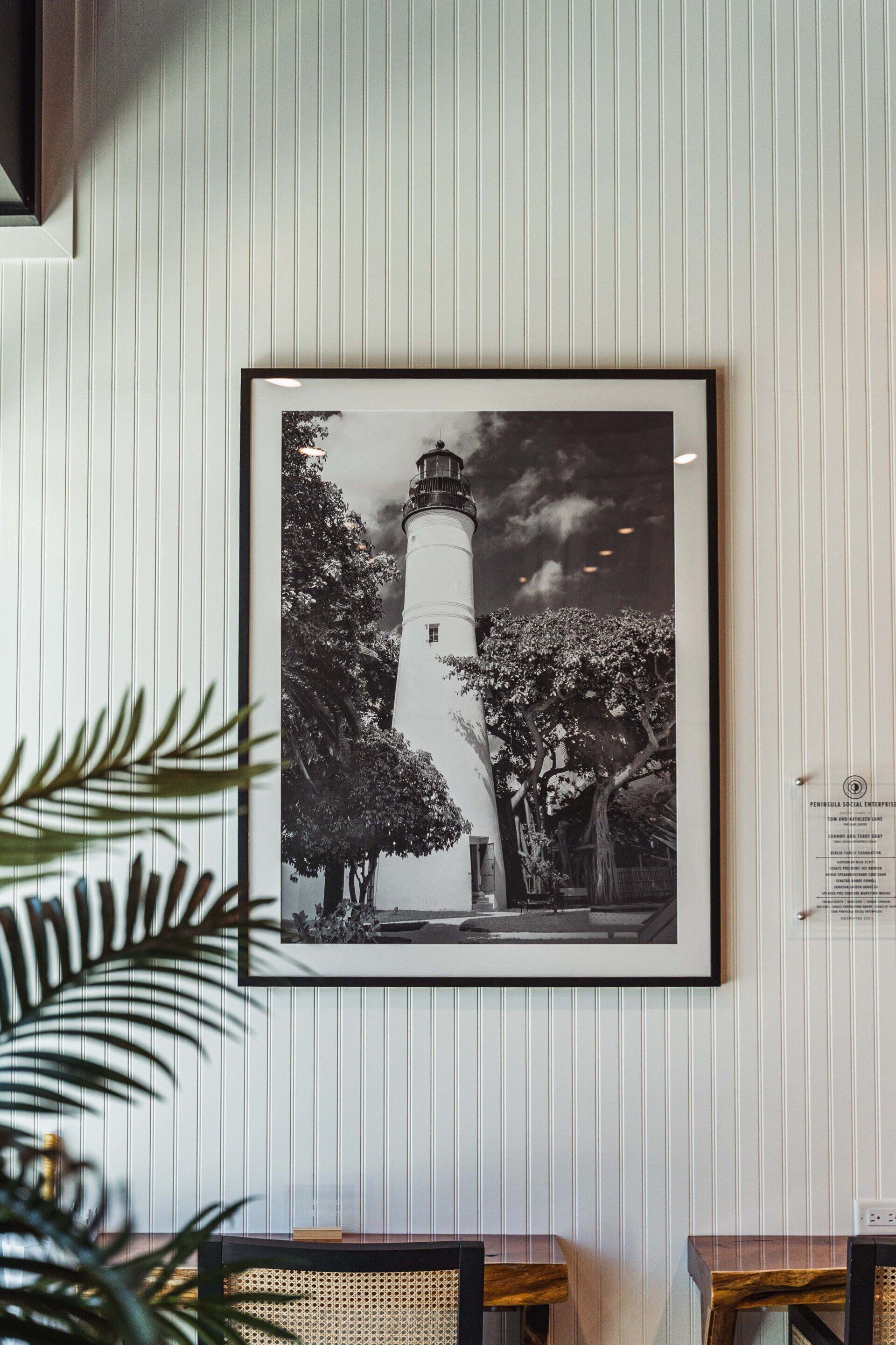 A black and white photo of a lighthouse hanging on a wall.