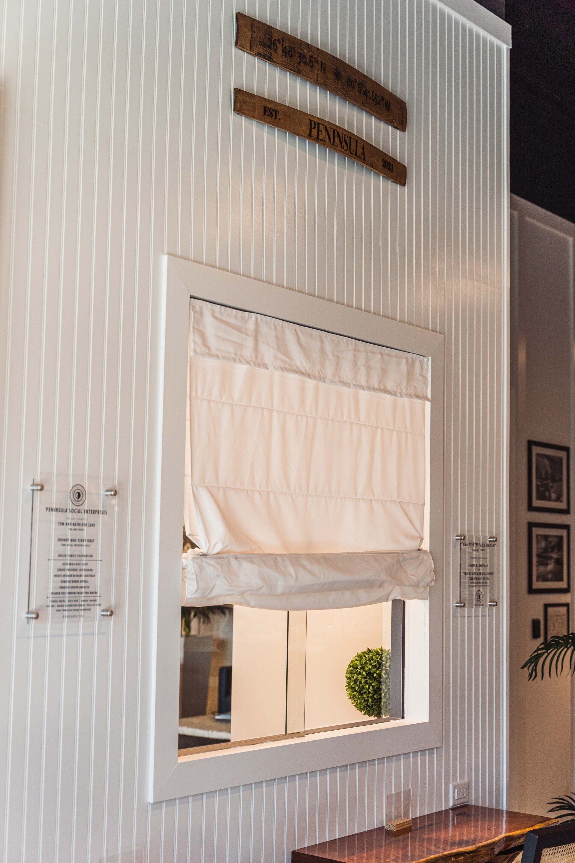 A white wall with a window and a sign on it