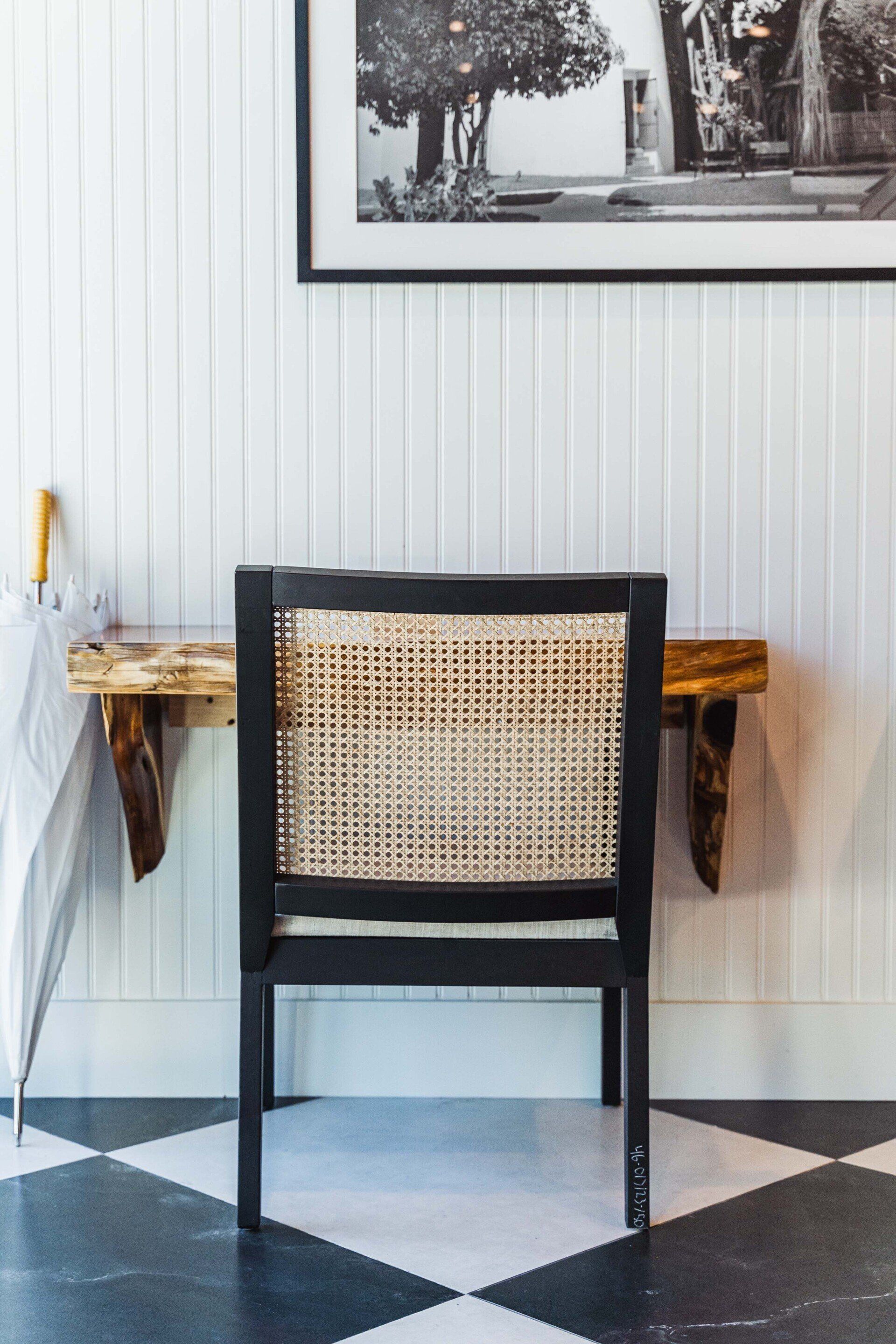 A chair is sitting next to a wooden desk with an umbrella on it.