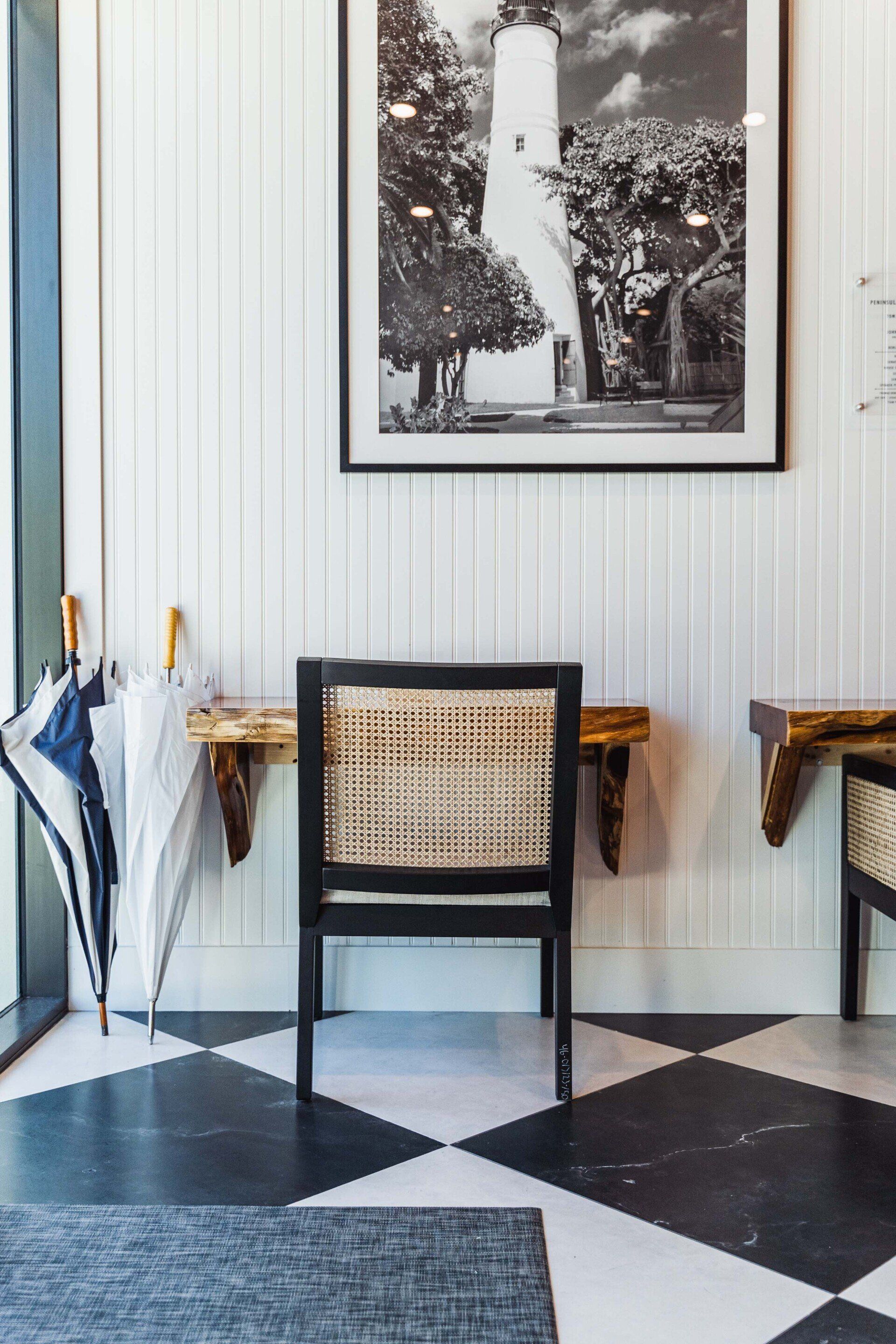 There is a picture of a lighthouse on the wall above the chair.