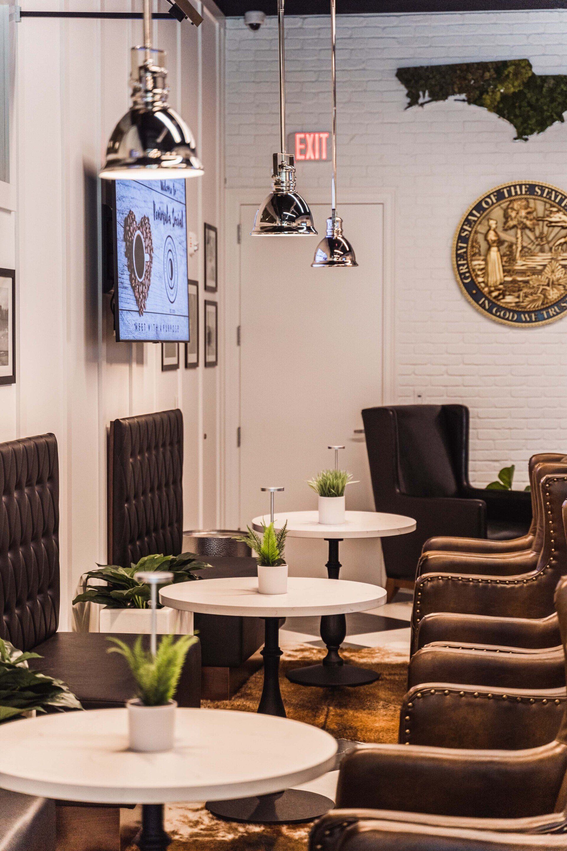 A room with tables and chairs and an exit sign