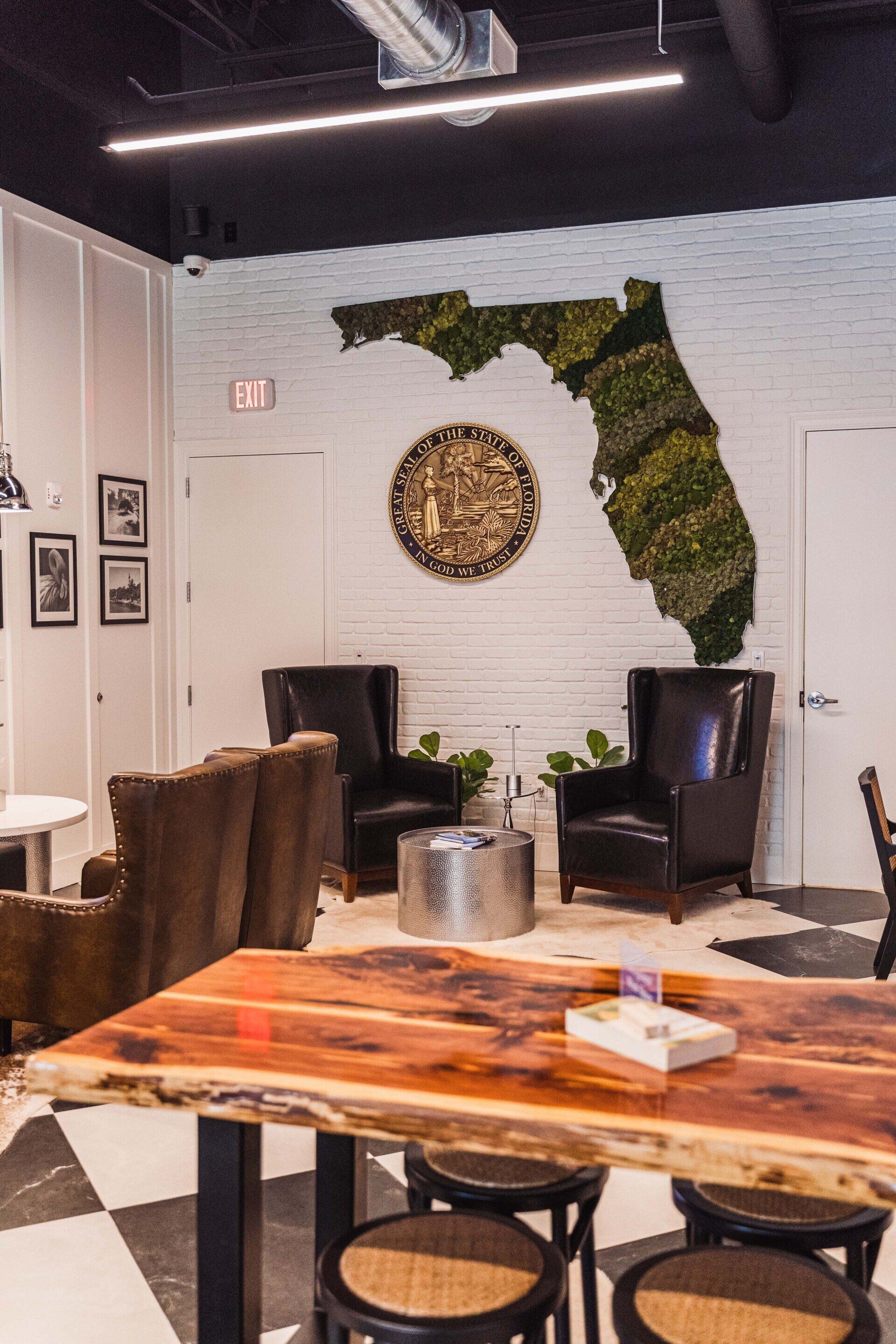 A room with a table and chairs and a map of florida on the wall