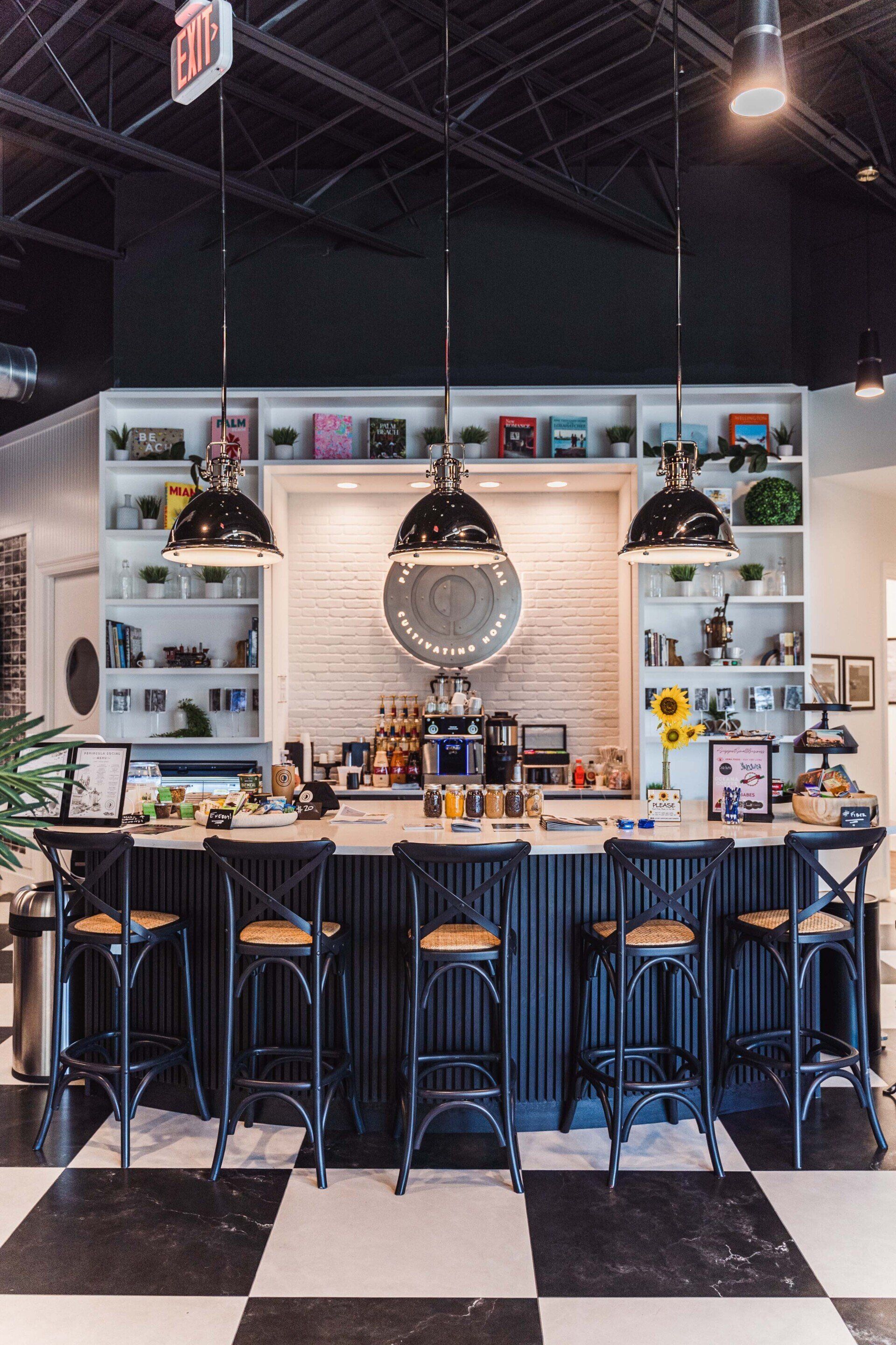 A restaurant with a checkered floor and a long bar with stools.