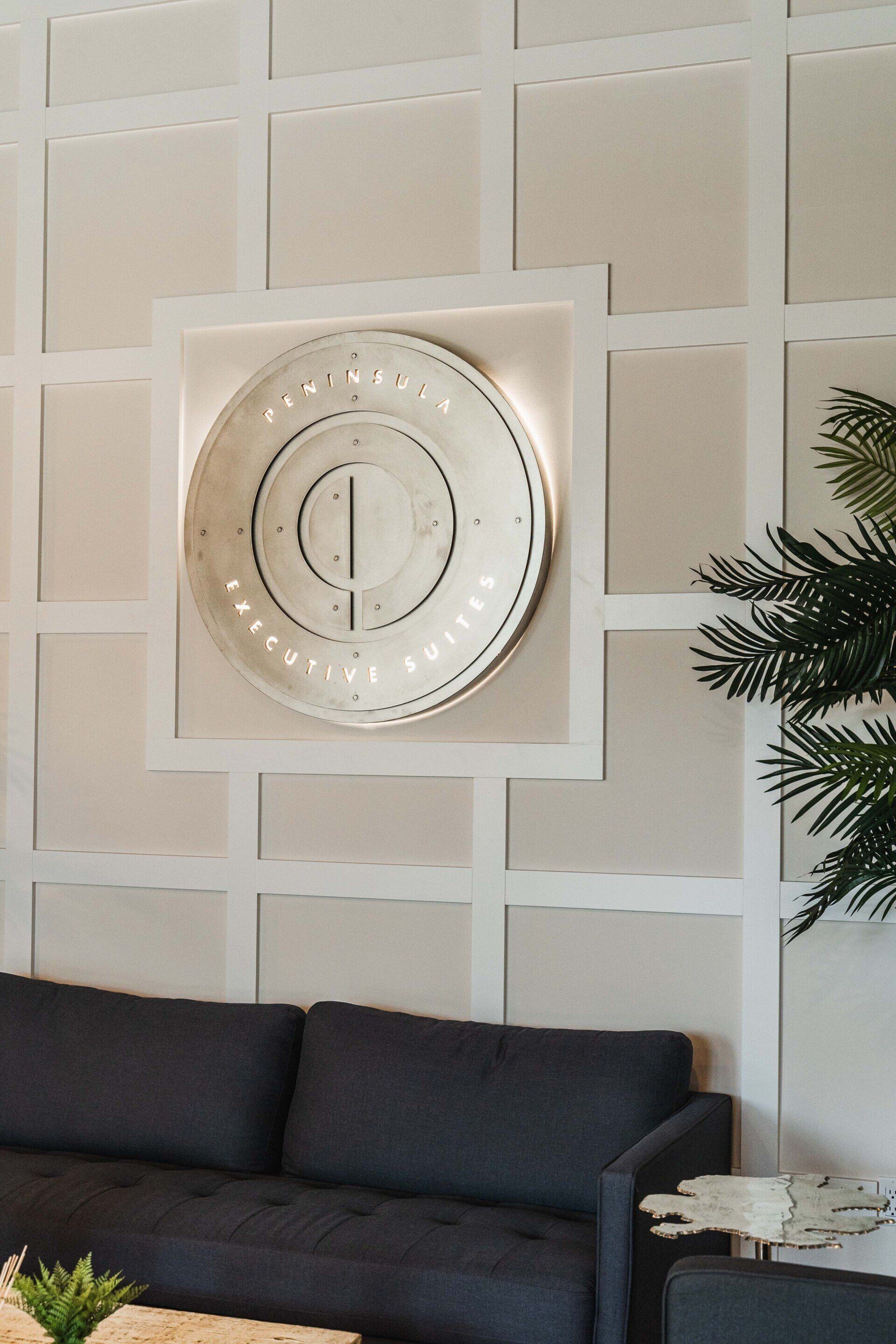 A living room with a couch and a clock on the wall