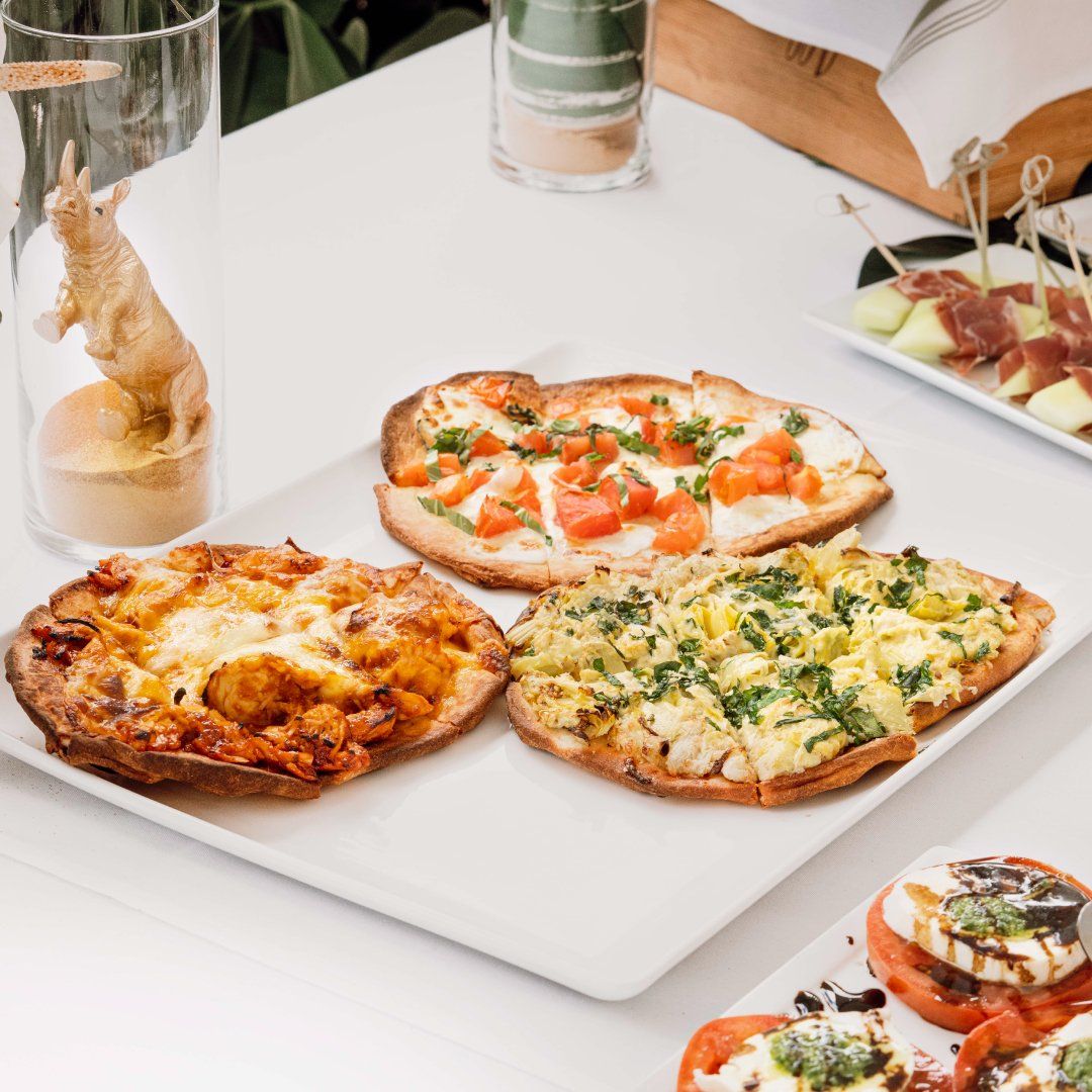 Four pizzas are on a white plate on a table