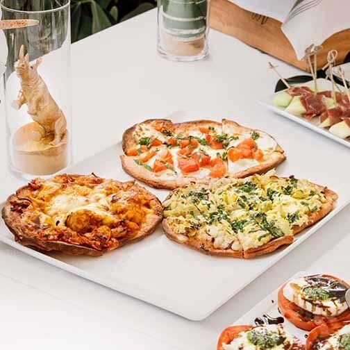 Three pizzas are sitting on a white plate on a table.