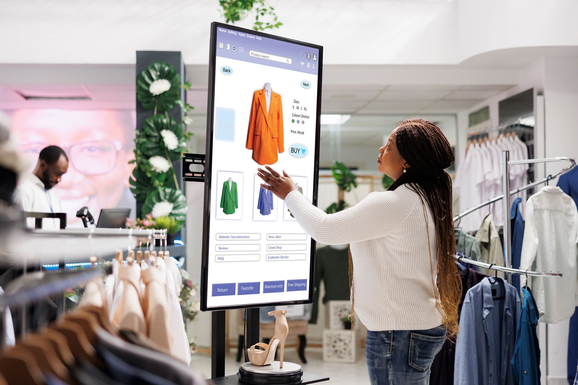 A woman is standing in front of a large screen in a clothing store.