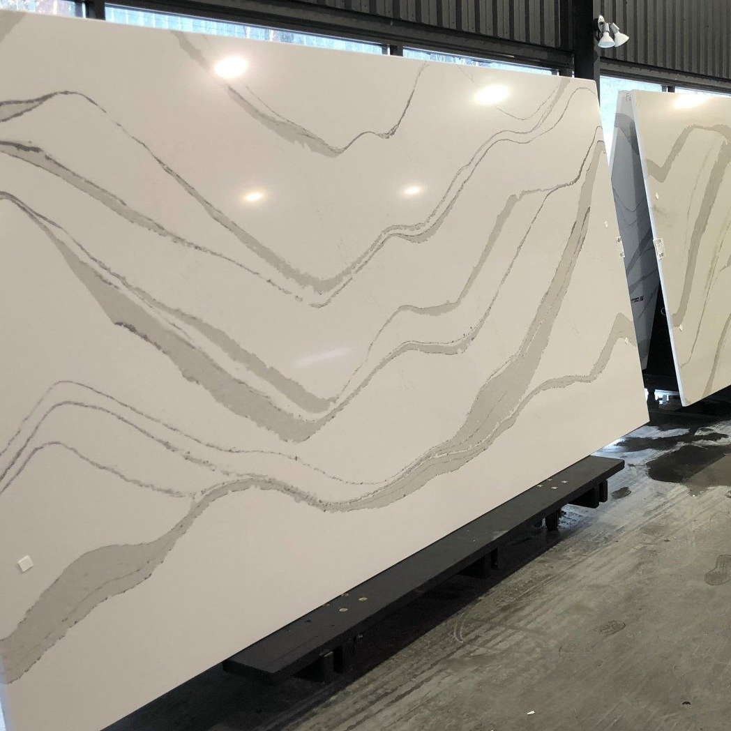 Large slabs of white quartz with gray veining, displayed indoors.
