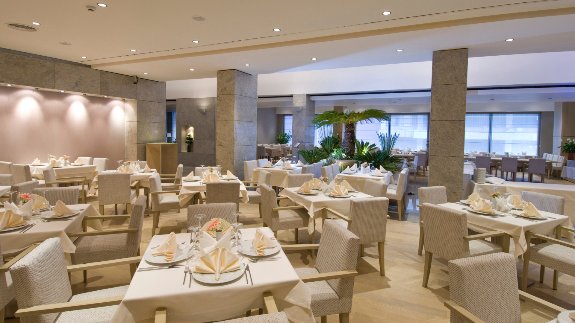 Yellow wet floor sign on polished floor, person cleaning with a floor buffer.
