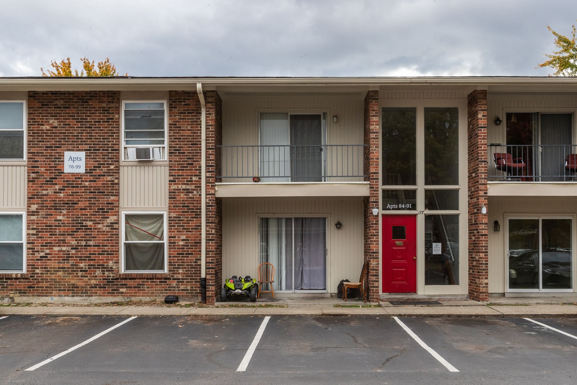 A brick apartment building with a red door