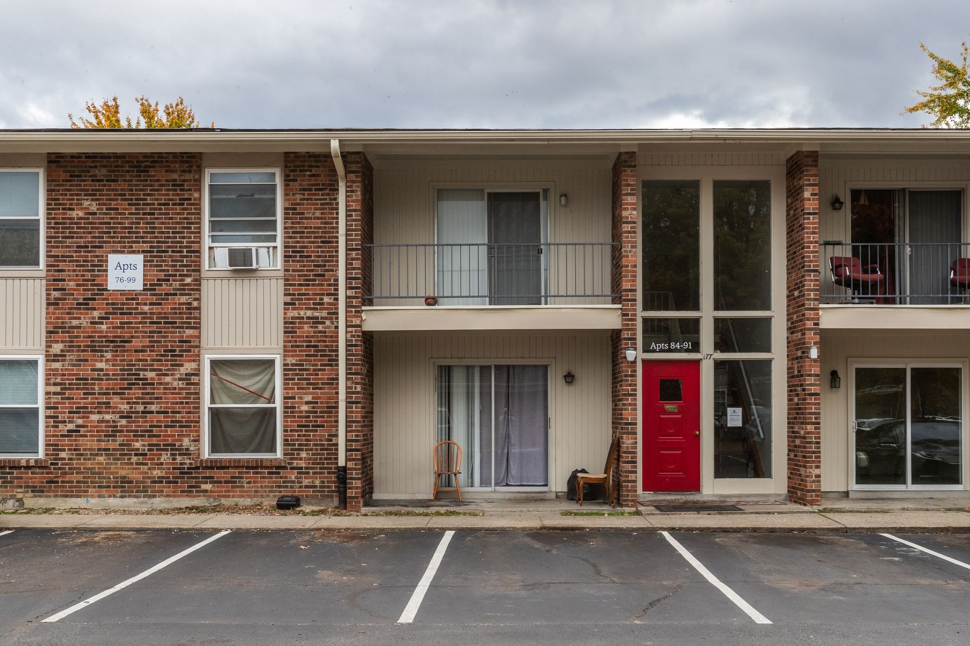 A brick apartment building with a red door and balconies