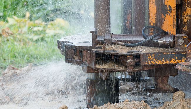 A close up of a water well with water coming out of it.