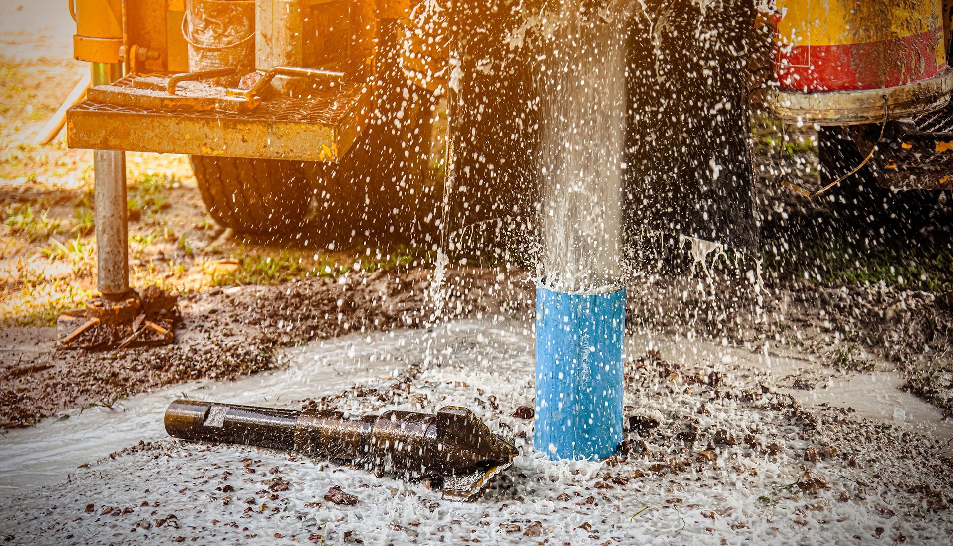 A water pump is being used to pump water out of a hole in the ground.